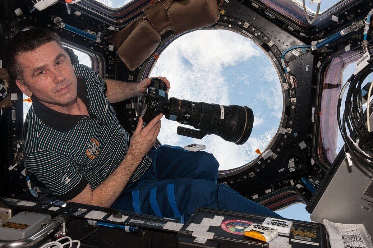 4.Бортинженер программы «Экспедиция 47» Ю.Маленченко в одном из модулей космической станции подготавливается к фотосъемке планеты, используя четырехсот-миллиметровую линзу.