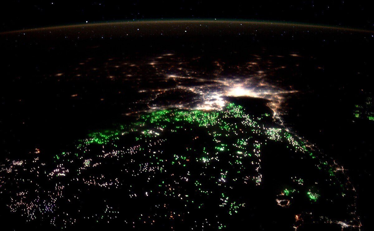 Море освещается зелеными прожекторами рыболовных судов в Сиамском заливе.